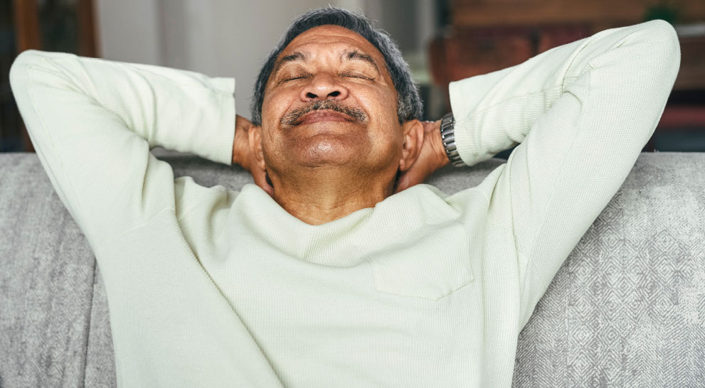 Older man leaning back relaxing with his hands behind his head | Presbyterian Village Athens Older man leaning back relaxing with his hands behind his head | Presbyterian Village Athens