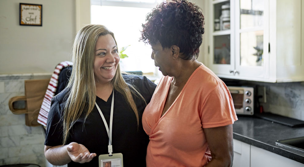 Caregiver smiling with arm around respite care resident | Presbyterian Village Athens Caregiver smiling with arm around respite care resident | Presbyterian Village Athens